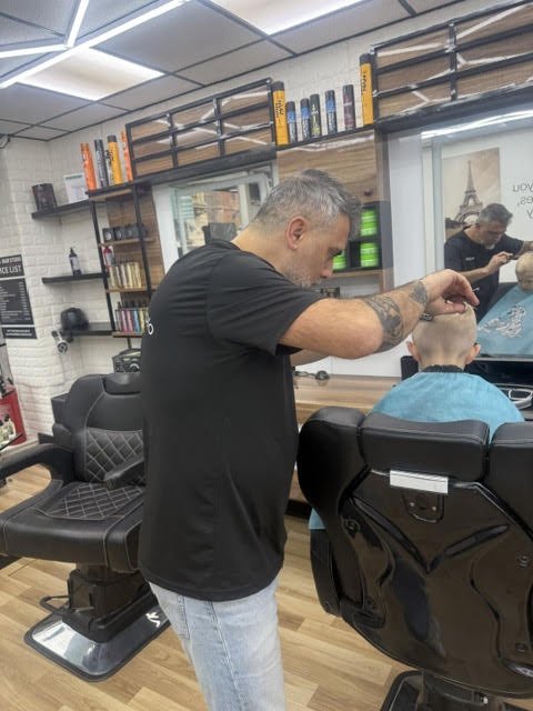 Barber giving a young client a fresh cut in the shop