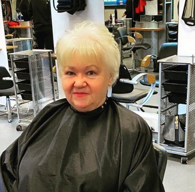 Client smiling with a fresh blonde pixie cut